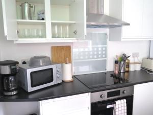 a kitchen counter with a microwave and a stove at Stoneley Stays by Urban Hazelnut in Crewe