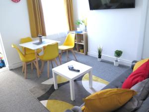 sala de estar con sofá, mesa y sillas en Stoneley Stays by Urban Hazelnut en Crewe