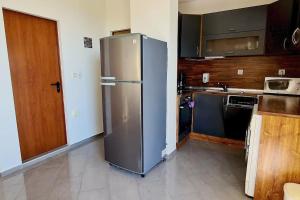 a kitchen with a stainless steel refrigerator in it at Seagarden Villa Resort / Villa Dimar 2C in Lozenets