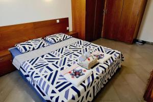 een bed met een zwart-wit dekbed en een dienblad met een oven bij Seagarden Villa Resort / Villa Dimar 2C in Lozenets