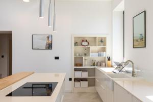 a kitchen with white cabinets and a sink and a counter at Villa B with Old town & sea view in Dubrovnik