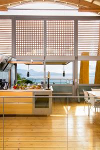 a kitchen with a large window with a view of the ocean at Athina Epavlis - Ethereal Charm of Blue Horizons in Ravdhoúkha