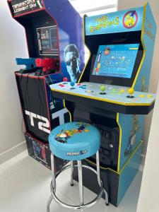 uma arcada de jogos de vídeo com um banco azul ao lado de um sistema de jogos em Enjoy our Luxurious Penthouse in Condado! em San Juan