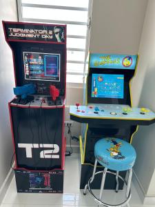 uma máquina de jogos de vídeo, uma mesa e um banco em Enjoy our Luxurious Penthouse in Condado! em San Juan