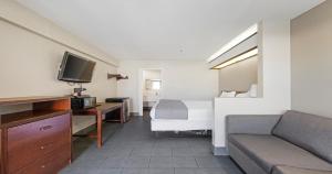 ein Hotelzimmer mit einem Bett und einem Sofa in der Unterkunft Budget Inn and Suites Stockton Yosemite in Stockton
