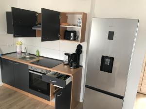a small kitchen with a refrigerator and a sink at Erholungszeit - Mein kleines Paradies in Bad Kreuznach