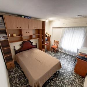 a bedroom with a bed and shelves and a window at Beach Apartment in Cullera in Cullera