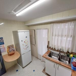 a kitchen with a white refrigerator and a sink at Beach Apartment in Cullera in Cullera