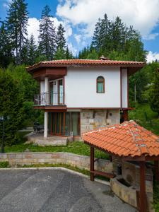 uma pequena casa com um alpendre e uma varanda em Pamporovo Cottage Savov em Pamporovo