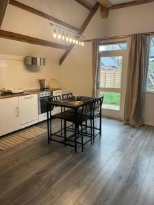 a kitchen with a table and chairs in a room at Leuke bungalow in Noord-Holland in Opmeer