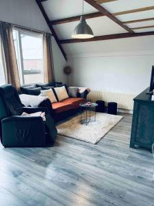 sala de estar con sofá y mesa en Leuke bungalow in Noord-Holland, en Opmeer