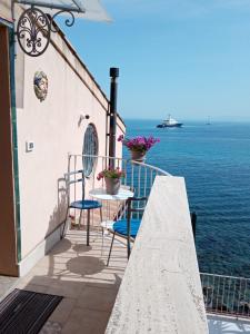 a balcony with a table and chairs and the ocean at Rosa dei venti in Scilla