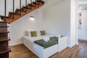 Cama blanca en habitación con escalera en Villa Amour Charming Duplex Apartment on Marina en Quarteira