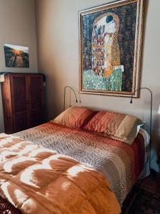 a bedroom with a bed with a painting on the wall at Su Casa in Ensenada