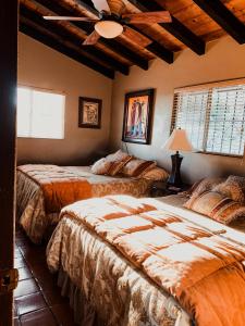 a bedroom with two beds and a ceiling fan at Su Casa in Ensenada