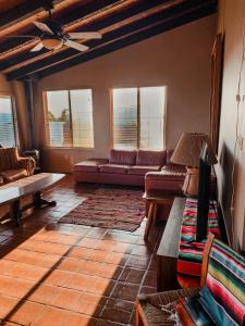 a living room with a couch and tables and windows at Su Casa in Ensenada