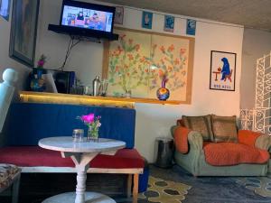 a living room with a table and a couch and a tv at Casa Antaña in San Miguel de Allende