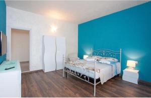 a bedroom with a bed with a blue wall at Da Claudietto in San Teodoro