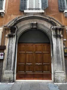 un ingresso a un edificio con una grande porta in legno di Room Verona Mamma Bianca a Verona