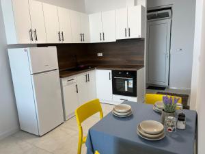 a kitchen with a blue table and white cabinets at Aliara Dilara Beach Apartments in Pomorie