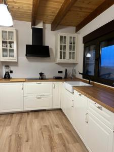 cocina con armarios blancos y suelo de madera en Casa El Santanderino, en El Espino