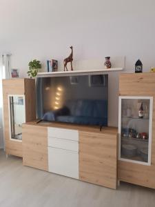 a large television in a wooden entertainment center at Apartamento Holydais Monica in Murcia