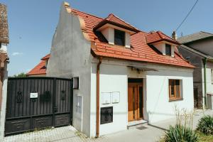 a white house with a red roof and a gate at Luxury style apartment in Šaštín