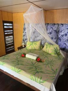 Una cama con dosel con flores. en Moanaiti Lodge, en Maheva 68 fotos más