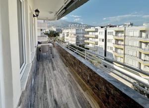 balkon ze stołem, krzesłami i budynkami w obiekcie Stunningly family apartment w mieście Alanya
