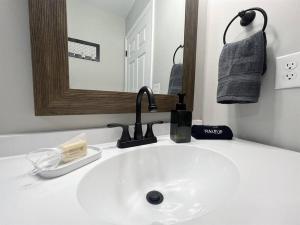 W łazience znajduje się biała umywalka i lustro. w obiekcie The Otter Box Cabin - 92 Acres Beside DeSoto State Park w mieście Fort Payne