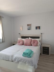 1 dormitorio con 1 cama con almohadas rosas y verdes en Apartamento Holydais Monica, en Murcia