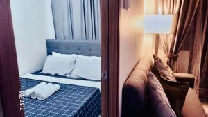 a room with a bed and a lamp and a window at Shore 3 Tower 1 MOA Pasay F Suite Staycation in Manila