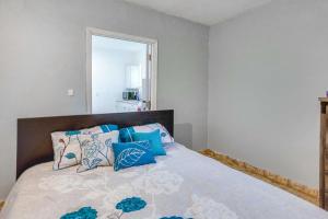 een slaapkamer met een bed met blauwe en witte kussens bij Boynton Beach Vacation Rental about 4 Mi to Beach! in Boynton Beach