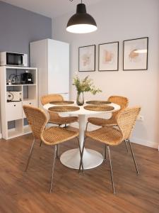 a table and chairs with a vase on it at Apartamento Luis de Vargas in Huelva