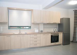 uma cozinha com armários de madeira e um frigorífico de aço inoxidável em Angie’s apartment em Kiverion