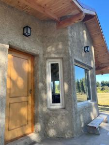 una casa con puerta y ventana en Casa de Campo La Chacra en San Carlos de Bariloche