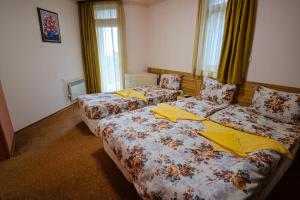 2 bedden in een hotelkamer met gele lakens bij Pamporovo Cottage Savov in Pamporovo