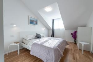 a white bedroom with a bed and a window at Apartment Meri in Dubrovnik