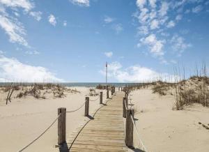 a wooden boardwalk in the sand on a beach at Sugar Sands-Luxury 1st Floor 2BR 2BA Private Beach in Gulf Shores