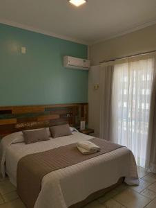 um quarto com uma cama grande e uma janela em Pousada Vô Jaques em Porto Belo