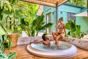 two people sitting in a hot tub on a deck at The Oasis at Puket in Manzanillo