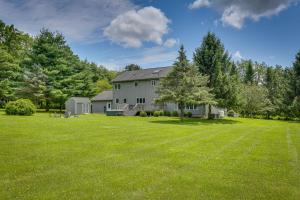 a large yard with a house in the background at Warwick Vacation Rental with Private Yard and Fire Pit in Warwick