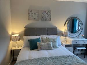 sypialnia z łóżkiem z 2 lampami i lustrem w obiekcie Willow Tree Cottage w mieście Ballycastle