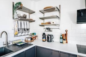 a kitchen with black cabinets and white tiles at Principality View Apartment Three, by Solace Stays in Cardiff