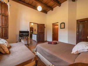 a bedroom with two beds and a flat screen tv at Casita Del Escritor in Antigua Guatemala