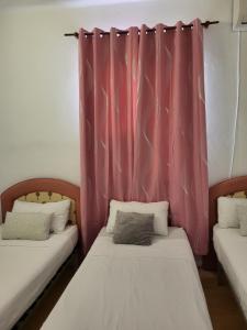 2 Betten in einem Zimmer mit rosa Vorhang in der Unterkunft Ático en el Corazón de Sevilla in Sevilla