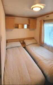 Postel nebo postele na pokoji v ubytování Carnaby Holiday Caravan, West Sands, Selsey