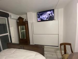 Monolocale con terrazzo solare في بيروجيا: غرفة نوم مع تلفزيون بشاشة مسطحة على جدار