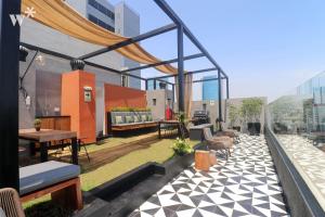 a rooftop patio with furniture on a building at Alta by Wynwood House in Lima