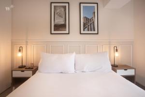 a bedroom with a large white bed with two lamps at Alta by Wynwood House in Lima +206 photos
